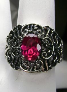 "Simulated Ruby Ring Nouveau Design#16 Custom Made Inspired by Victorian and Art Nouveau designs I now offer this stunning Antique reproduction in sterling silver. This gorgeous ring is set with a stunning 8 x6mm faceted Simulated Red Ruby (Approximately 1ct). The ring sits 15.5mm (5/8th\") North-South NS on the finger. Notice the beautifully intricate design of the silver filigree setting. This is an exquisite rendition of an antique filigree ring and can be made in just about any ring size. Fe Oval Silver Ruby Ring With Filigree, Oval Silver Ruby Filigree Ring, Silver Ruby Filigree Ring, Victorian Sterling Silver Ruby Ring, Ornate Silver Ruby Ring Hallmarked, Star Ruby Ring, Natural Ruby Ring, Antique Filigree, Gorgeous Ring