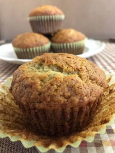 three muffins sitting on top of a table next to plates of cupcakes