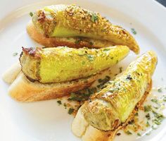 three pieces of bread on a white plate with sprinkles and seasoning