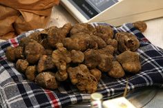 a pile of potatoes sitting on top of a blue and white checkered cloth next to a scale