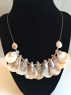 Reversible Ivory/Beige Teardrop Shell Necklace on 18 inch Satin Hamilton gold plated .8mm chain ~ SW117L This hand-crafted necklace features nine (9) iridescent ivory/beige teardrop shells measuring approximately 1" wide by 1-1/4 to 1-1/2" high, divided by gold and iridescent ivory seed beads strung on a delicate .8mm satin hamilton gold plated beading chain and finished with small coin-shaped freshwater pearl beads and a lobster claw clasp.   This necklace is REVERSIBLE!  I prefer wearing the necklace showing the textured organic inside of the shells, with the smooth back against the body.  But, you decide!   Wear this necklace alone, or pair it with one of my bead necklaces and bracelets that I will be listing.  (I have it pictured above with my Mother of Pearl choker necklace MP121L, wh Pearl Necklace With Briolette Cut For Anniversary, Gold Teardrop Pearl Pendant Jewelry, Gold Pearl Teardrop Pendant Jewelry, Gold Briolette Pearl Necklace, Handmade Gold Pearl Necklace With Briolette, Gold Drop Necklace With Pearl, Pearl Drop Teardrop Necklace, Gold Pearl Teardrop Pendant Necklace, Gold Teardrop Jewelry With Pearl Drop