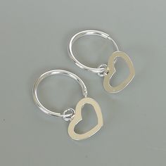 A PAIR of sterling silver hoops. Comes with a detachable heart charm. The charm is multipurpose and can be used with a neck or bracelet chain too. Dimension: Hoop- 14 x 1.5 mm Heart: 11 x 11 mm Price listed is for a PAIR of hoops. These earrings are made of 925 hypoallergenic sterling silver and comes with a 925 stamp. Can be packaged in a gift box. I can include a personal message from you if needed You are welcome to contact me at... bhavnakwintra1956@gmail.com For more beautiful pieces from m Silver Sterling Heart Charm Huggie Earrings, Silver Sterling Huggie Earrings With Heart Charm, Silver Small Hoop Earrings With Heart Charm, Silver Hoop Earrings With Heart Charm, Dainty Sterling Silver Hoop Earrings With Heart Charm, Small Hoop Sterling Silver Heart Earrings Hypoallergenic, Hypoallergenic Small Hoop Heart Earrings In Sterling Silver, Nickel Free Small Hoop Silver Heart Earrings, Nickel-free Small Hoop Heart Earrings In Silver