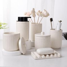 white bathroom accessories with flowers in vases