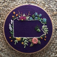 a purple circle with flowers and leaves on it, in the shape of a letter d