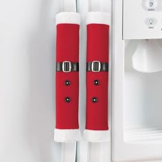 two red and white christmas stockings hanging from the side of a refrigerator