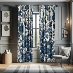 a blue and white floral curtain hanging in front of a window with curtains on both sides