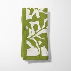 a green and white napkin with leaves on it