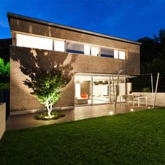 a modern house lit up at night in the yard