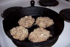 four muffins cooking in a skillet on top of the stove burners