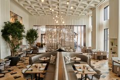 the interior of a restaurant with high ceilings and wooden tables set up for dinner or lunch