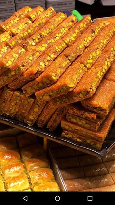 there are many pieces of food on the trays in this display case and one is stacked high