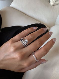 a woman's hand with three diamond rings on her left and two diamonds on her right