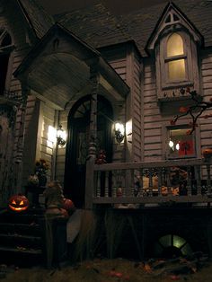 an old house decorated for halloween with pumpkins on the porch