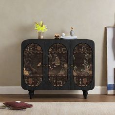 a black cabinet sitting on top of a hard wood floor next to a white rug