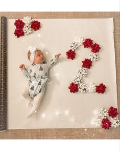 a baby laying on top of a sheet of paper with the numbers 2 and 3 spelled out