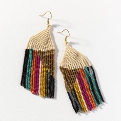 the multicolored beaded earrings are hanging from gold earwires on a white background