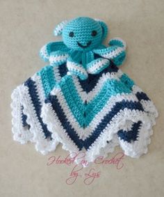 a crocheted octopus is sitting on top of a blue and white striped blanket