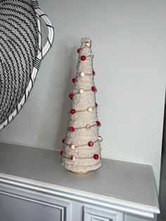 a small white christmas tree sitting on top of a shelf