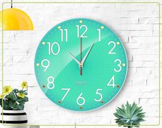 a green clock on the wall next to a potted plant and yellow light bulb