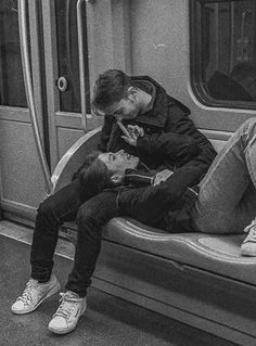 two people are sitting on a subway train