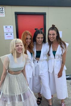 four girls dressed in white posing for the camera