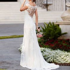 a woman in a wedding dress is looking at her cell phone while standing on the sidewalk