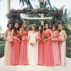 a group of women standing next to each other in front of a gazebo with flowers