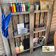 a wooden shelf filled with lots of different types of paint and pencils on top of it