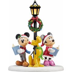 mickey and minnie mouse figurines are standing next to a lamp post