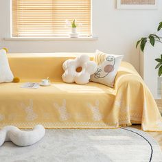 a living room with a yellow couch and white rugs on top of the floor