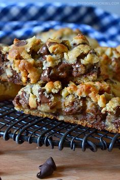 chocolate chip cookie bars on a cooling rack with one cut in half to show the filling