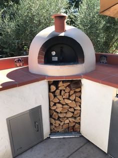 an outdoor pizza oven with firewood stacked in it