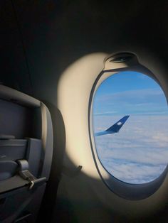 an airplane window looking out at the clouds