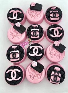 pink and black decorated cupcakes with chanel logo on the top one is made out of fondant