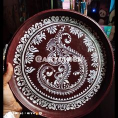 a person holding a decorative plate in their hand