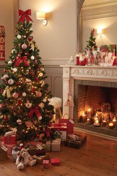 a decorated christmas tree in front of a fireplace with presents on the floor next to it