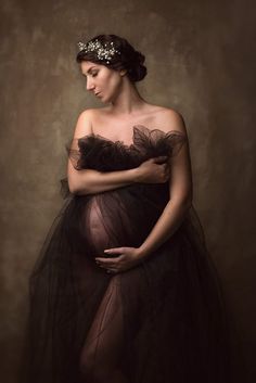 an image of a pregnant woman wearing a black dress and holding her hand on her stomach