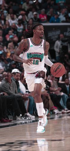 a basketball player dribbling the ball in front of an arena full of people