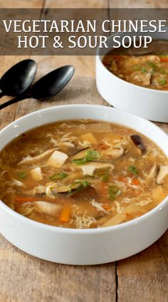 two white bowls filled with soup on top of a wooden table