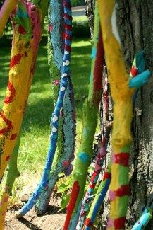 the colorful ropes are hanging from the tree