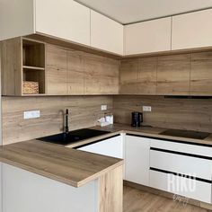 an empty kitchen with white cabinets and wood flooring on the counter top, is shown