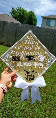 someone is holding up a graduation cap in the grass