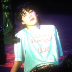 a young man standing in front of a microphone and wearing a shirt with the words stay calm on it