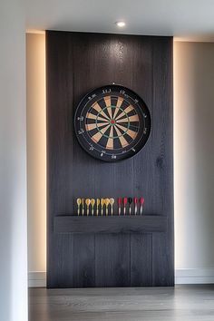 a dart board mounted to the side of a wall with darts in front of it