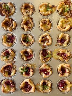 an assortment of pastries in muffin tins on a baking sheet with sprigs of rosemary