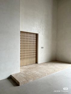 an empty room with a wooden door on the wall and tiled floor in front of it