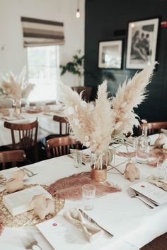 the table is set with white linens and silverware