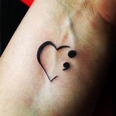 a small heart tattoo on the wrist