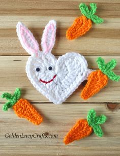 crocheted bunny with carrots on wooden surface