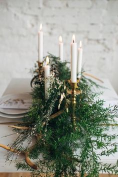 a table with candles and greenery on it